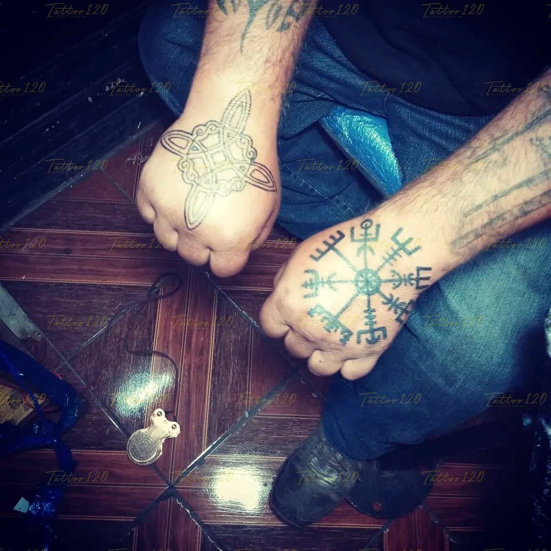 Tatuajes en los dorsos de las manos de dos personas que muestran una brújula rúnica Vegvísir y un diseño de nudo celta lineal, en estilo de polinesios y tribales, realizado en el estudio Tattoo120 en Colina, Región Metropolitana.