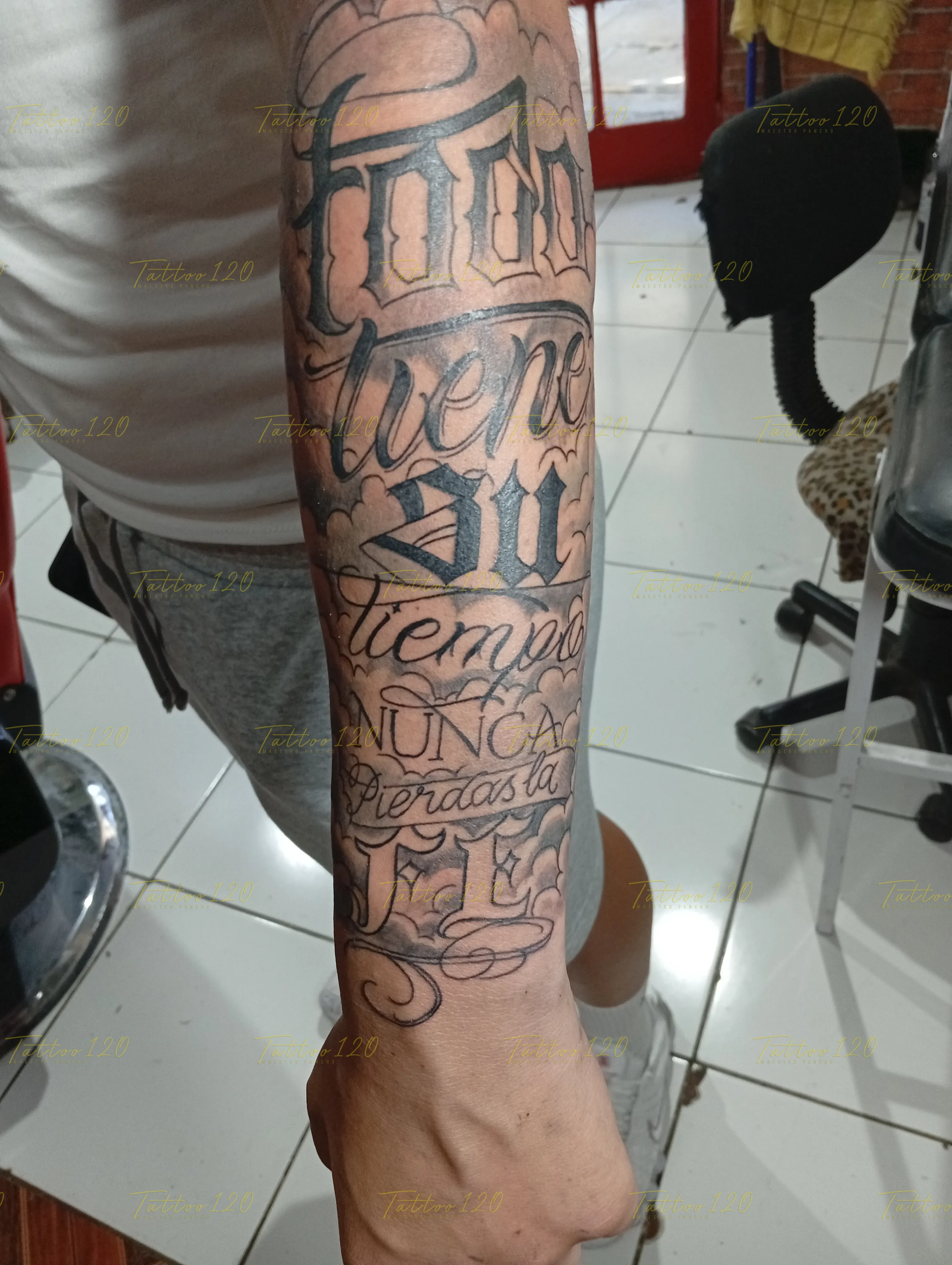 Tatuaje de letras y frases en caligrafía sobre el brazo y antebrazo